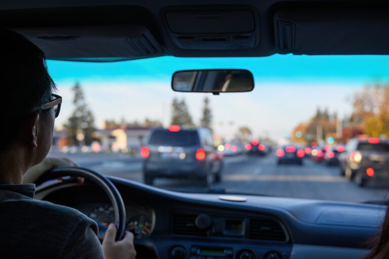 Driver navigating through urban traffic, keeping safe following distance. Red brake lights from vehicles ahead. California. USA